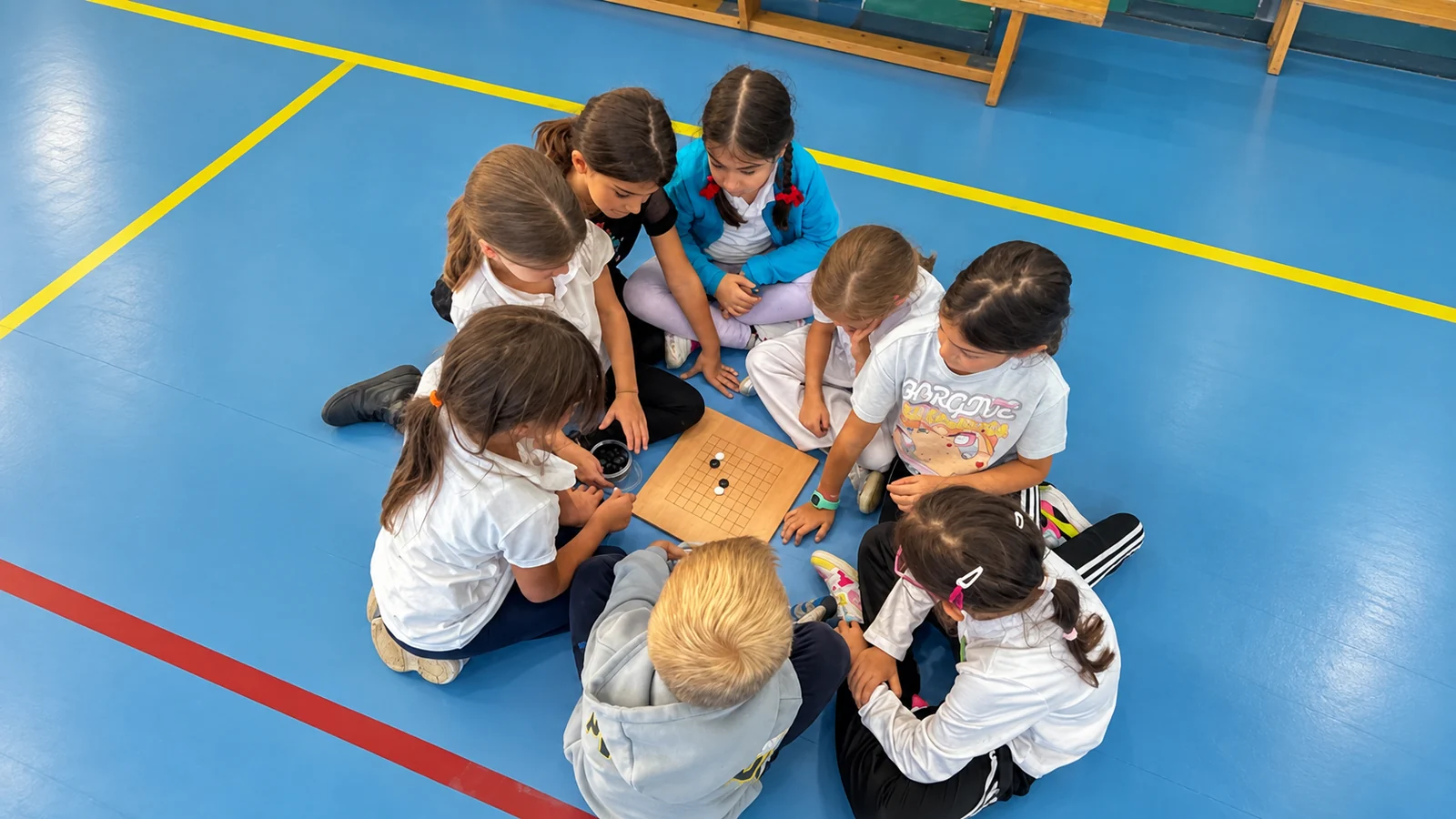 Elevi adunați în jurul unei table de Go